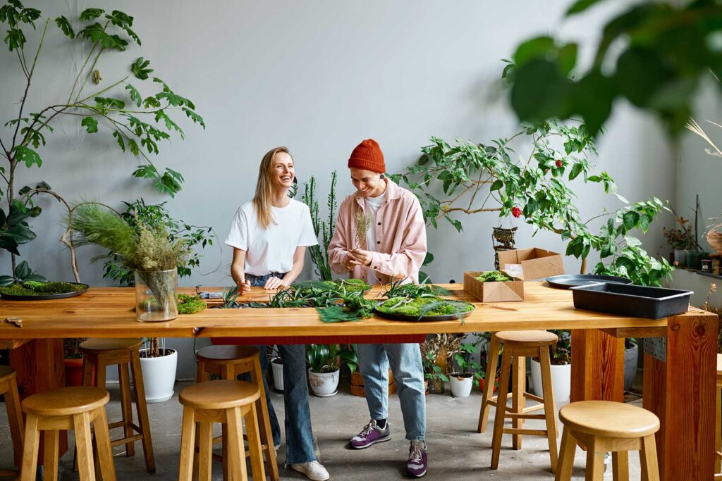 two-happy-and-smiling-young-florists-working-toget-ACXJE48.jpg